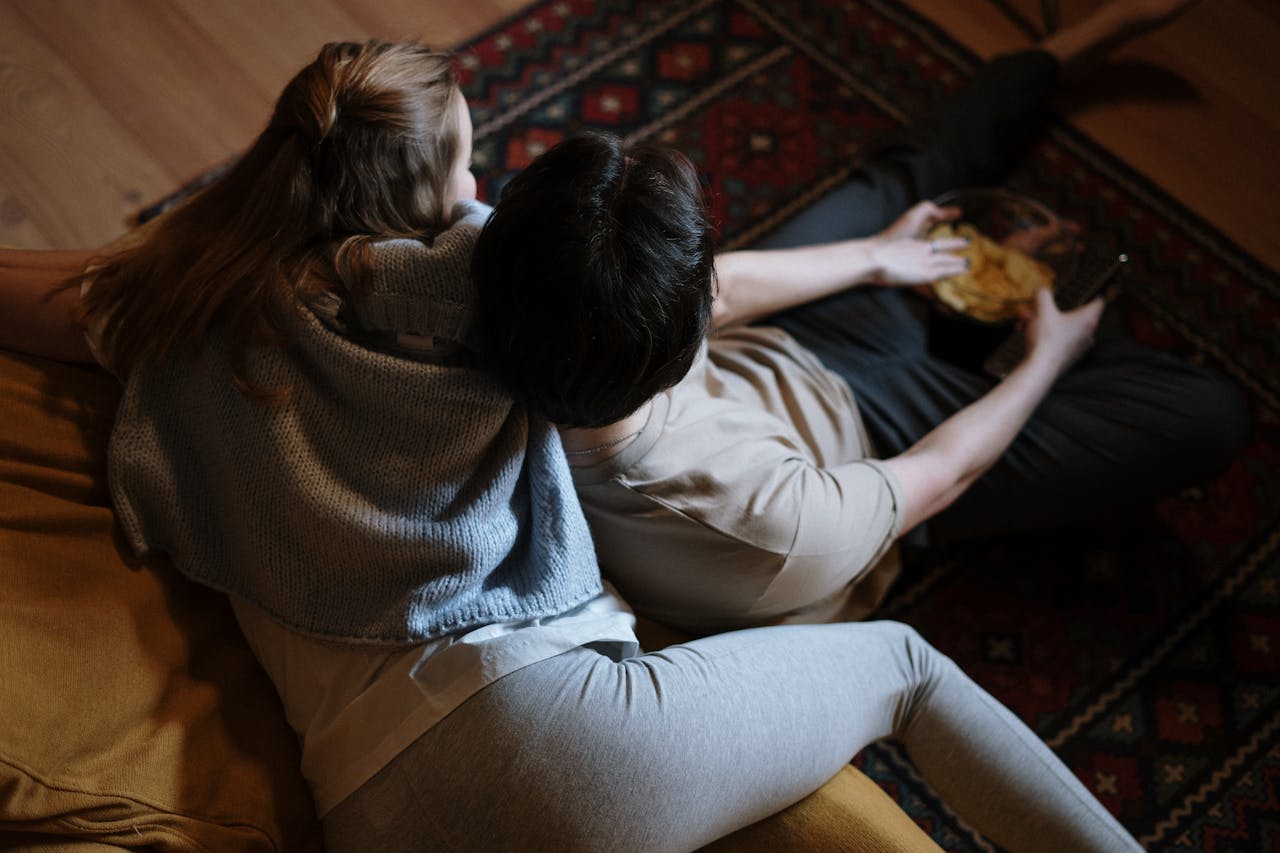 A couple relaxing on their couch at home, enjoying a quiet evening together indoors.